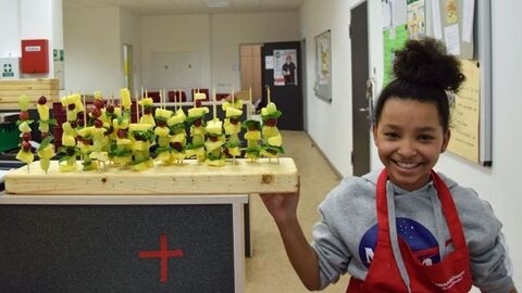 Kind neben Gemüsespießen