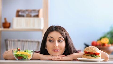 Kontaktformular Eine Frau - links Salat, rechts ein Burger