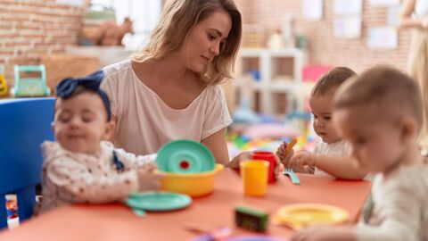 Vernetzungsstelle Kitaverpflegung Erzieherin mit Kindern am Essenstisch