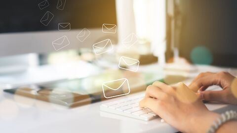 Tastatur mit Händen und E-Mail-Symbolen
